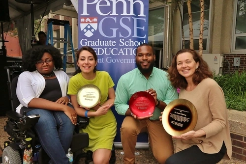 Four student winners holding their awards