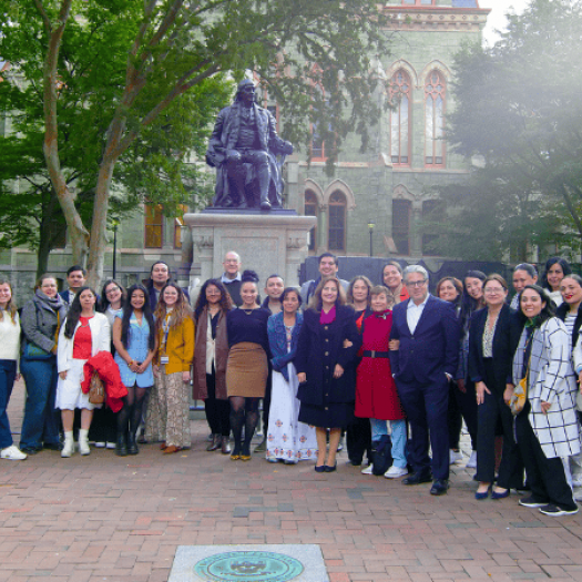 A large group of more than 30 academics from Penn GSE and University of Guadalajara pose for a group photo with the Ben Franklin statue on Penn’s campus.