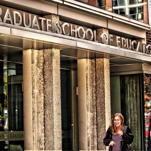 Two students walk in front of Penn GSE's building. 