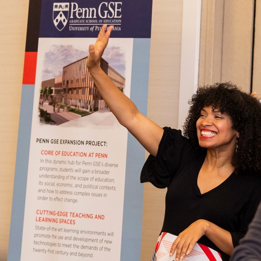 a woman waves in front of a GSE sign