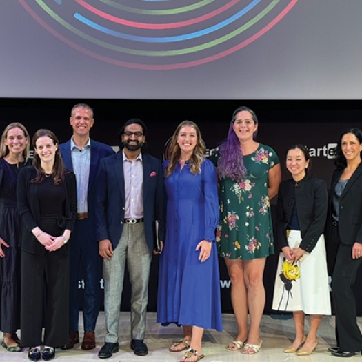 Unlocked Labs founder Jessica Hicklin (fourth from right), winner of the grand prize at the 14th annual Milken-Penn GSE Education Business Plan Competition, stands with others on stage at the competition finals