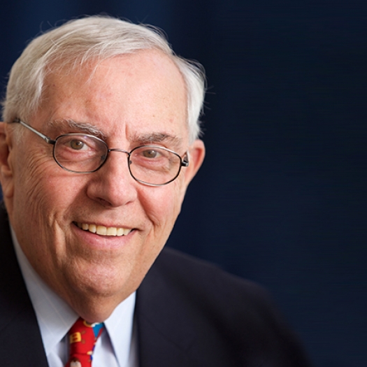 Smiling man with white hair and glasses