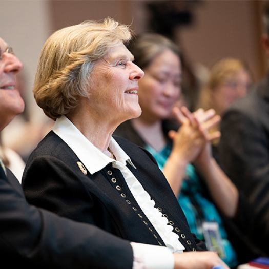 Suzanne McGraw is in the audience at an event, listening.