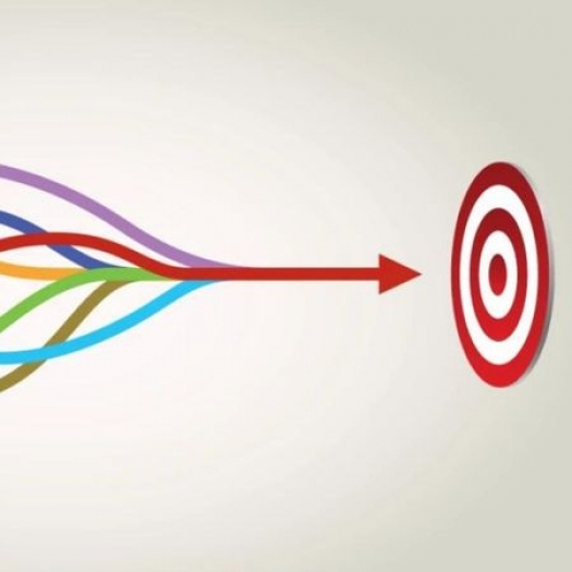 An illustration with a red-and-white circle target on the left. A bunch of squiggly lines, in a variety of colors, begin at the right and combine in the center to form one strong single line that continues into the bullseye of the target.