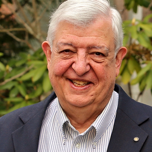 Smiling man with white hair and suit jacket