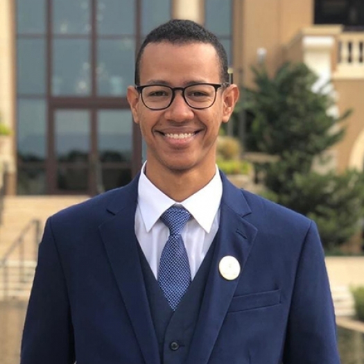 Abdulrahman Bindamnan smiling in a suit