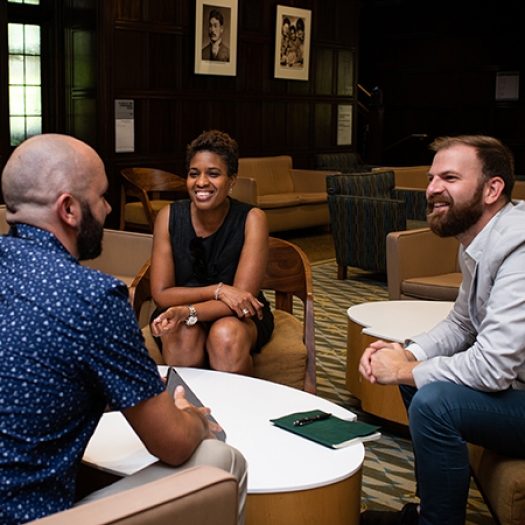 Penn GSE students sit in a lounge, conversing in a small group