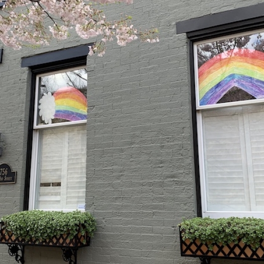 A house with drawings of rainbows in the window. 