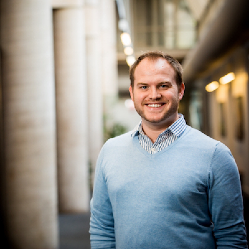 Smiling young man in blue sweater.