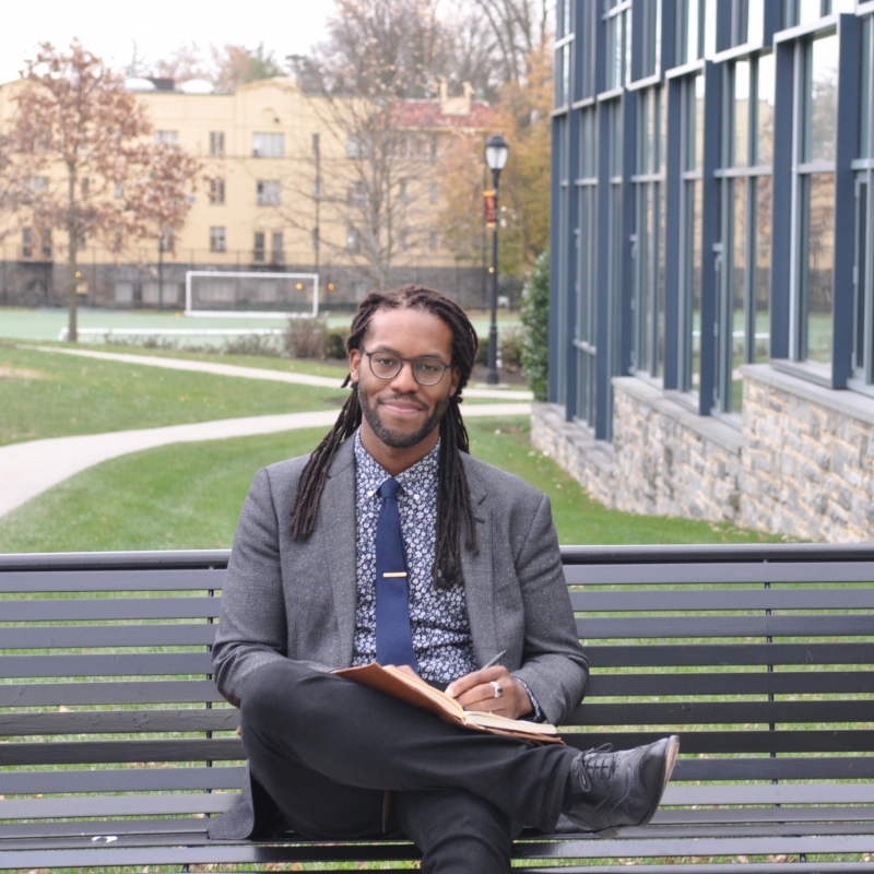 Brendon Jobs sitting on a bench on a campus