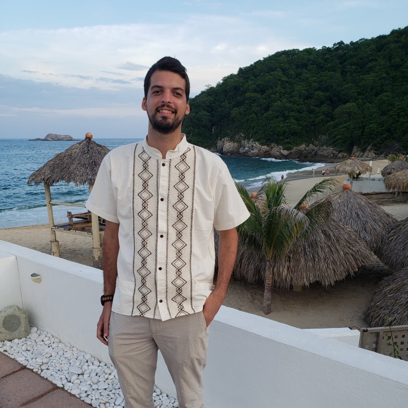 Diego Zelaya standing on a balcony above a beach