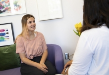 A young woman speaks with a counselor in an office