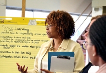 School leader stands in front of a large notepad in front of classroom