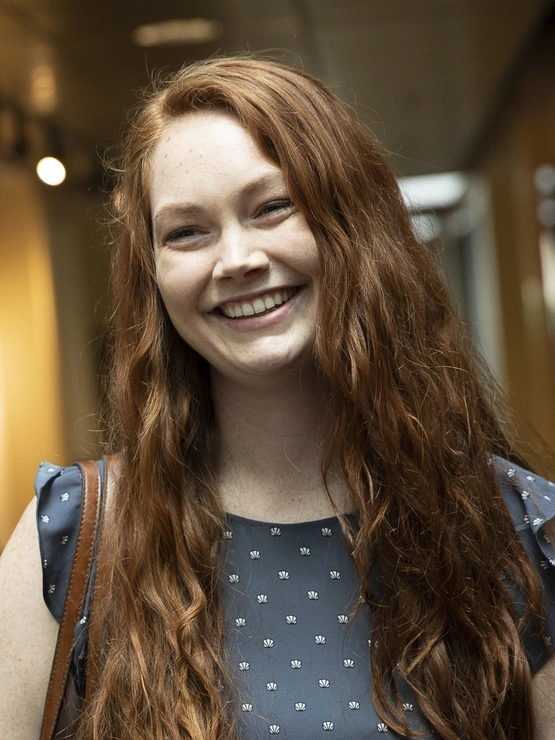 Female student smiling at a faculty member.