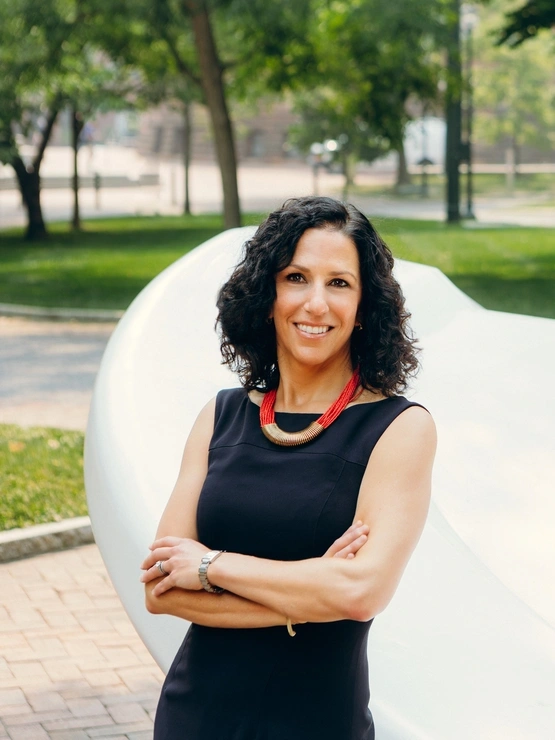 Dean Strunk poses in front of the button sculpture on Penn's campus