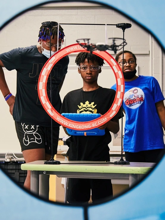 OSCE Summer Program Students flying a drone through obstacle course