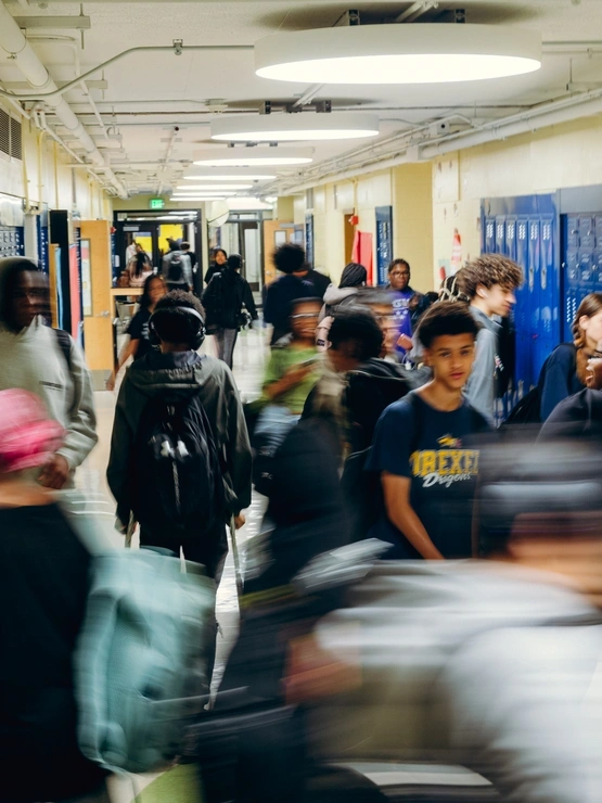 A slow motion image of high school students traveling through a hallway of a school between classes