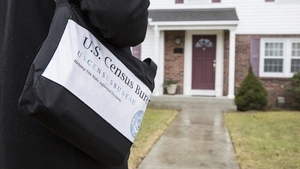 A U.S. Census worker approaches a house. 