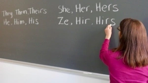 Woman writing on chalkboard.