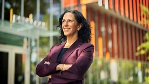 Penn GSE Dean Katharine Strunk stands arms folded in front of the entrance to the GSE building