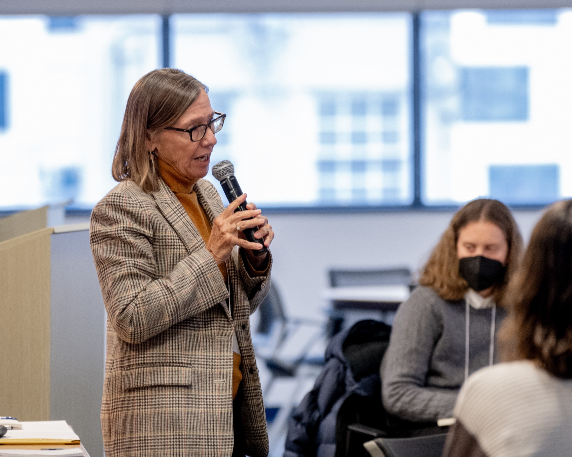 Penn GSE Professor of Education Pam Grossman speaks into a microphone at the front of a conference room while attendees sit and listen.