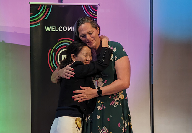 EJ Milken embraces Unlocked Labs founder Jessica Hicklin on stage after her venture won the grand prize at the 14th <span>annual</span> Milken-Penn GSE Education Business Plan Competition