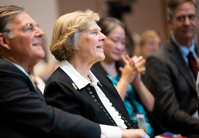 Suzanne McGraw is in the audience at an event, listening.