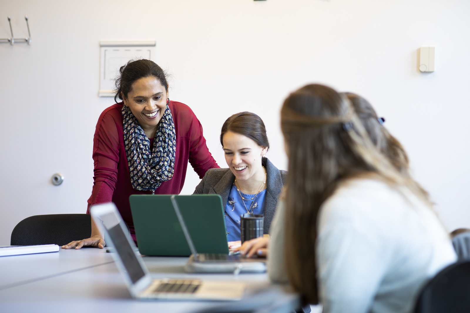 Betty Chandy works with students on laptops