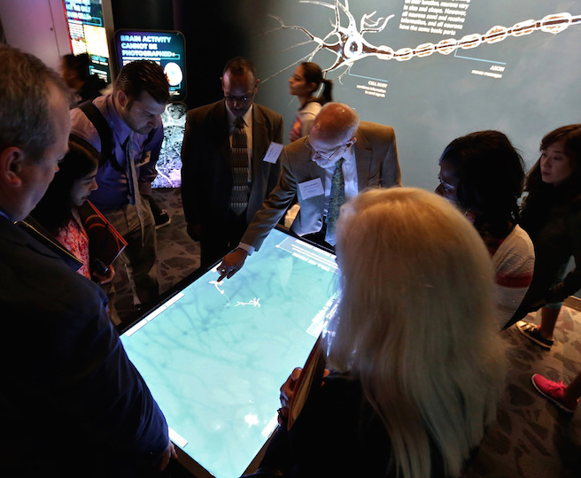 Superintendents around a multimedia exhibit