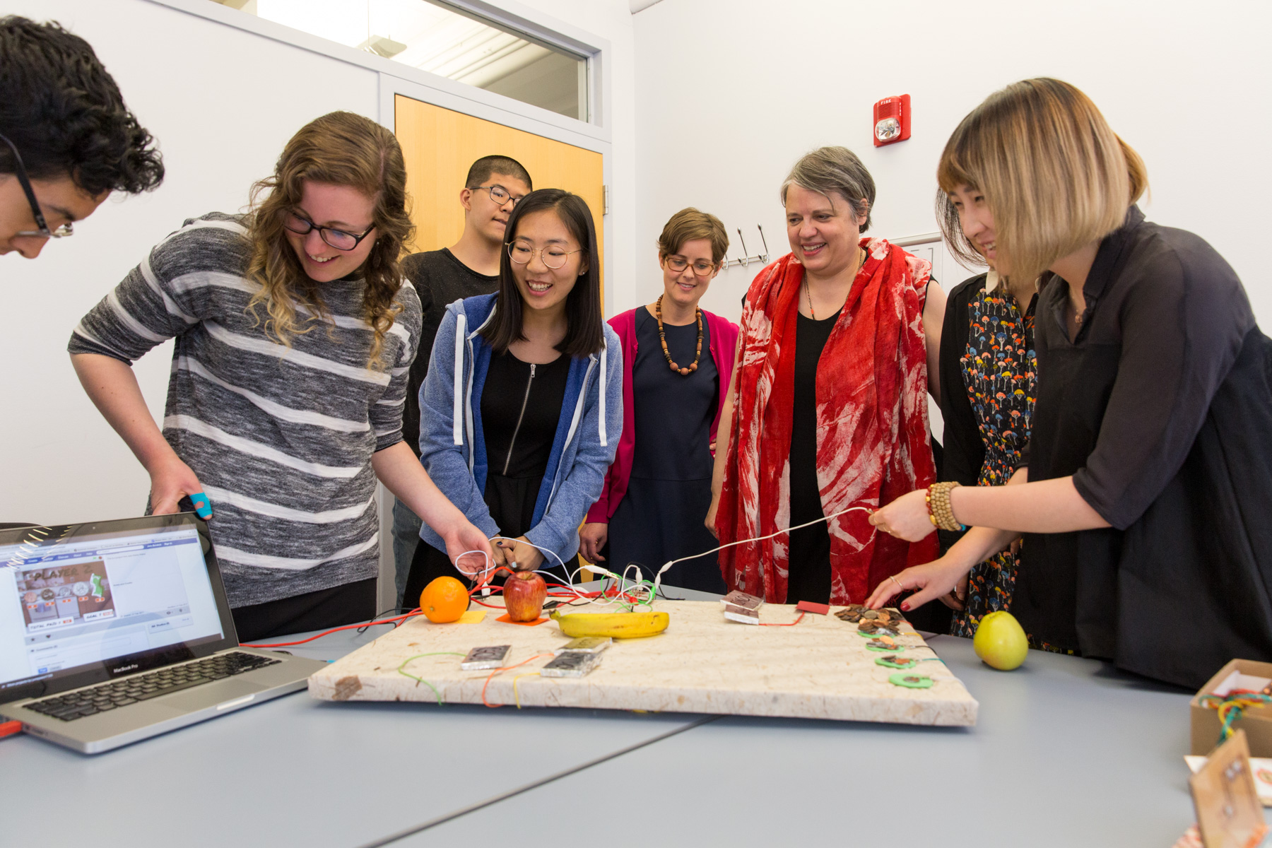 Students demonstrating a project to their class and professor with a electronic board with a computer chip